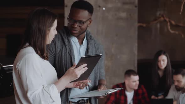 Two Office Workers Talking in an Loft Office Interior Young Business Colleagues Discussing Work on a