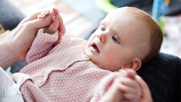 Dad Moving Baby Daughter Arms in Play