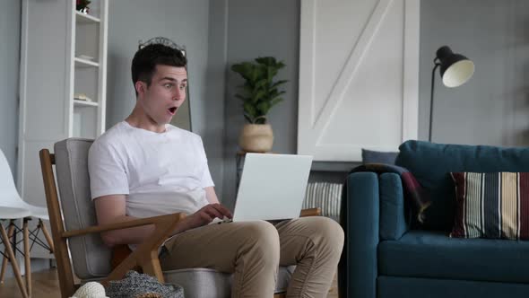 Casual Sitting Man in Shock While Working on Laptop