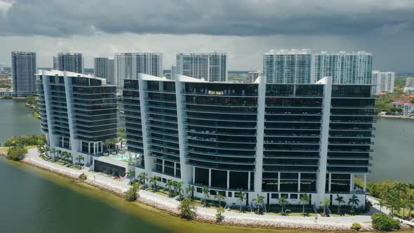 Modern Design Frontline Glass Building on Green Island in Miami Bay, Cloudy Day