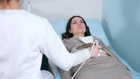 Woman in Suit Undergoes Ultrasonography of Abdominal Organs
