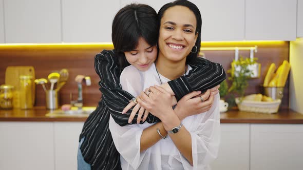 Closeup Portrait of Happy Lesbian Couple Embracing at Home in the Kitchen