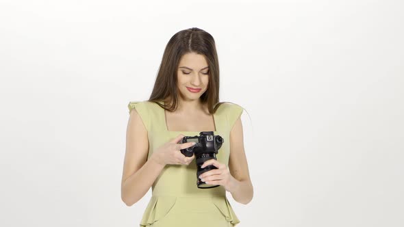 Girl Looks at the Results of the Photo Shoot on the Camera Screen. White