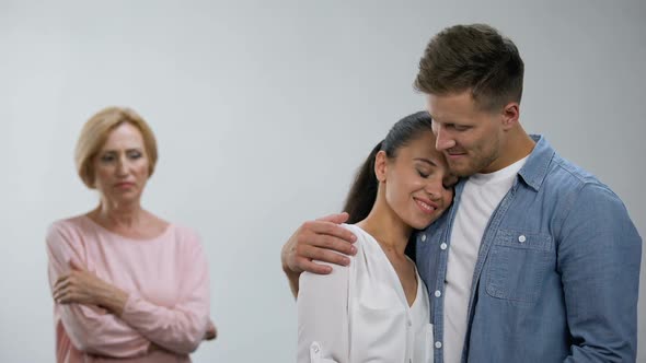 Offended Mother-In-Law Looking at Couple Tenderly Hugging, Lack of Attention