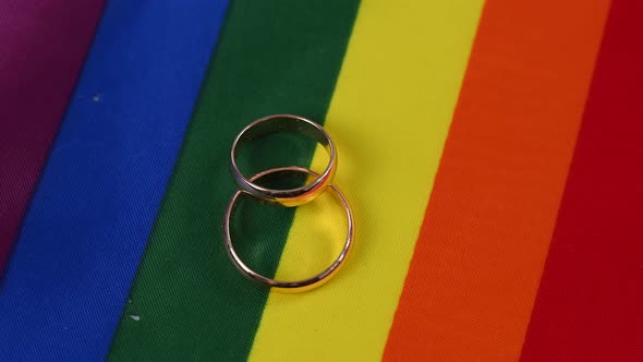 Two Wedding Rings Rotate on a Rainbow Flag