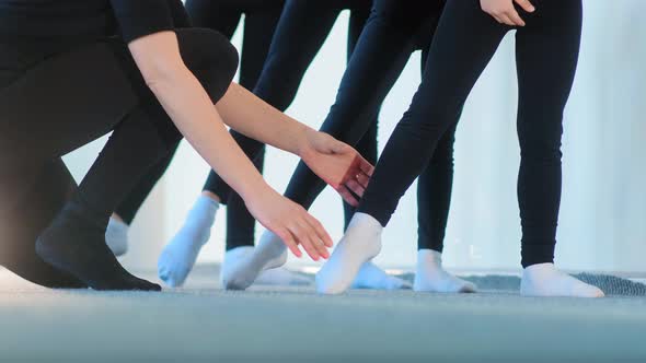 Ballet Teacher in Black Tracksuit Fixes Young Girls Feet