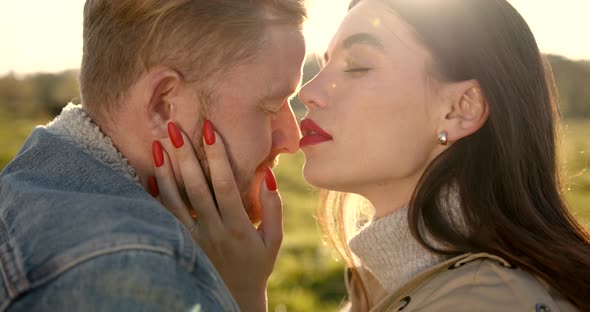 Loving Couple Hugging and Kissing on Meadow