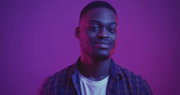 Portrait Cheerful African American Guy Turning Face To Camera Smiling Neon Lights Background