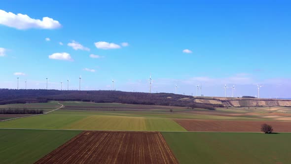 Panoramic View Of Fields And Wind Turbines Generating Alternative Energy On A Sunny Day. wide pan ri