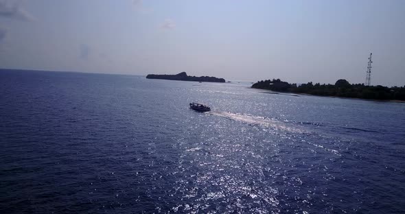 Luxury overhead clean view of a white sandy paradise beach and blue water background in vibrant 