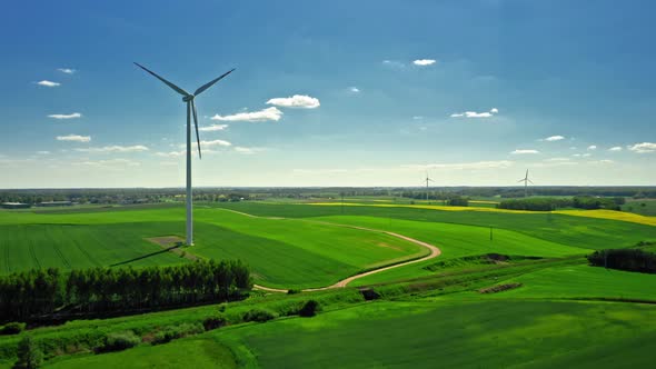 Stunning wind turbine and field of rapeseed in countryside.