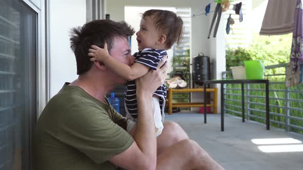 Dad and Son Have Fun Together the Kid Laughs When His Dad Tickles Him the Kid Slaps His Dad in the