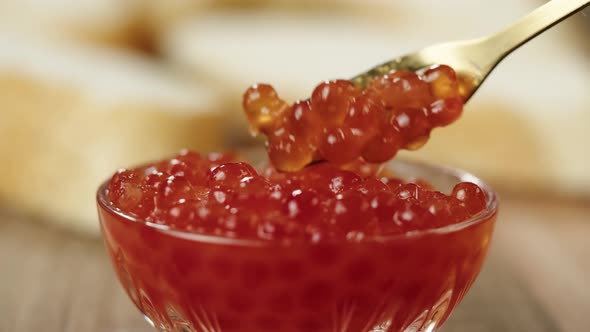 Mixing Red Caviar in Glass Bowl Closeup