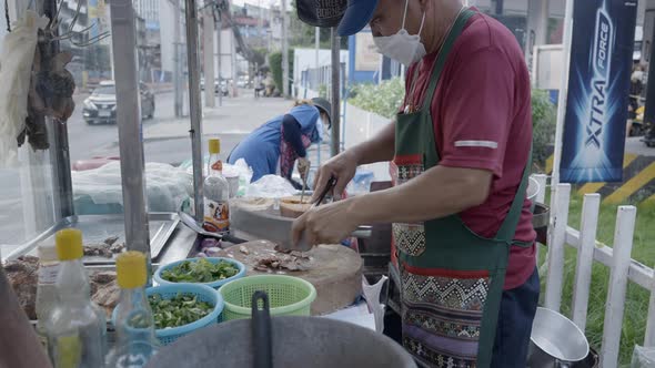 Thai Sidewalk Food Vendor Skillfully Chops Ingredients For Dish  Close Up Shot