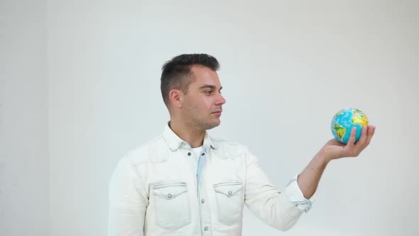 Young Modern Man in Modish Clothes Looking Over the Globe on white Background