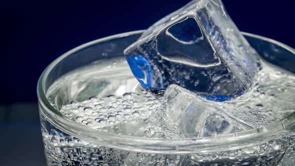 Glass of Water with Ice on a Dark Blue Background