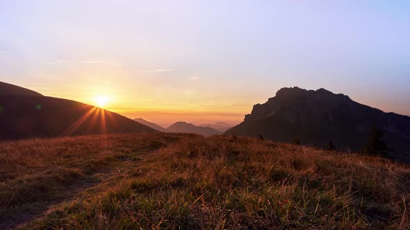 The setting sun in the mountains in national park, the grass illuminated by the sun's rays