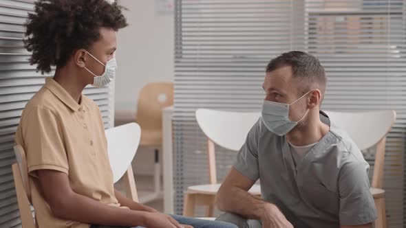 Cheerful Doctor Talking to Child Patient