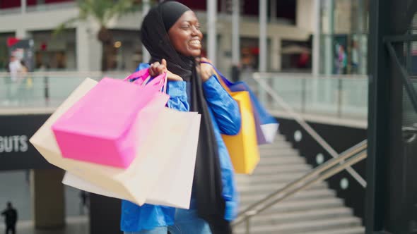 Cheerful Muslim Female Spinning Around After Shopping