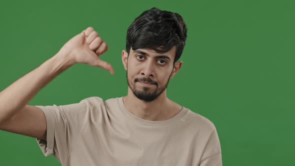 Unsatisfied Man Arab Indian Client Showing Thumb Down Negative Attitude with Disappointed Expression