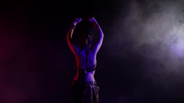 A Woman Who Dances an Oriental Dance on a Black Background in a Studio She Is Dressed in a Revealing