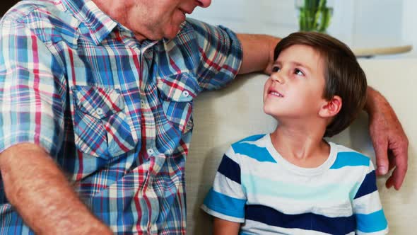 Smiling father and son using digital tablet in living room