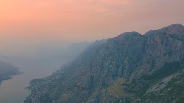 Sunset with fog view of Kotor bay and mountains in Montenegro. Aerial drone view 4K