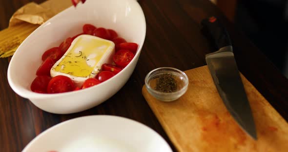 Step by step woman cooking feta cheese pasta, sprinkles with oregano