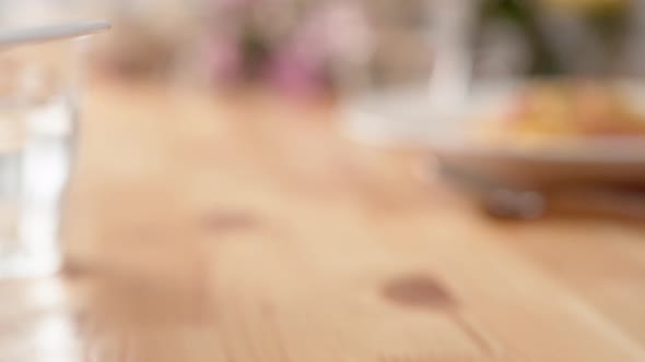 Camera follows carbonara pasta being served on table. Slow Motion.