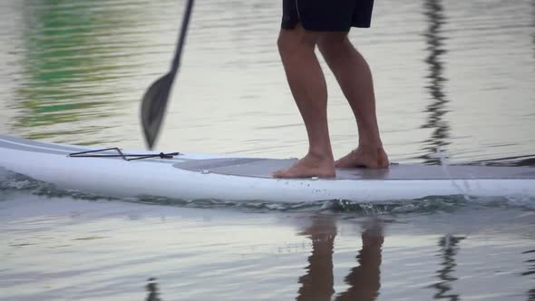 Extreme close up detail view of a man paddling his SUP stand-up paddleboard.