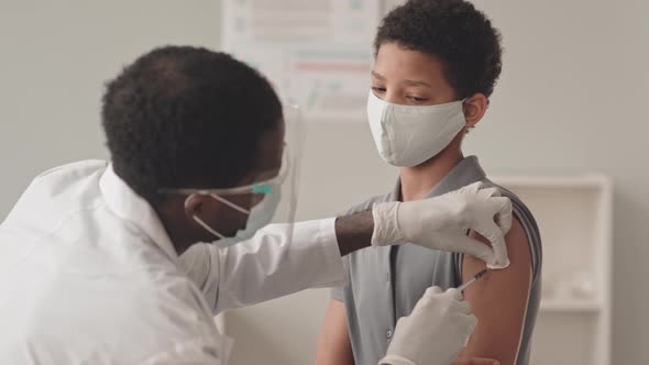 Doctor Doing Vaccine Injection to Schoolgirl