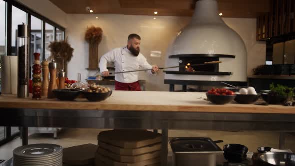 Chef Man Cooking Pizza Italian Food in Professional Kitchen Restaurant Stove