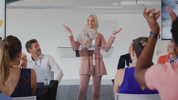 Female speaker and applauding audience at a business conference