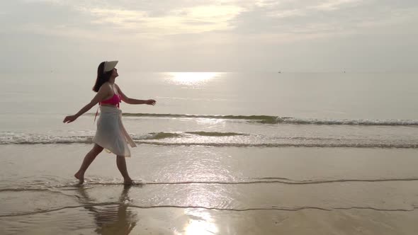 slow-motion of woman in bikini walking on the sea beach