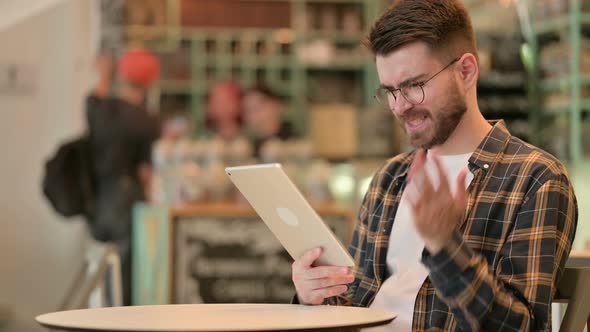 Failure, Young Man with Loss on Tablet in Cafe 