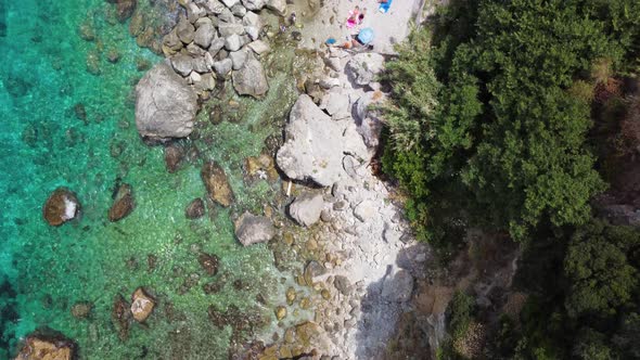 Overhead Aerial View of Island Coastline and Tourists From a Drone Italy in Summer Season