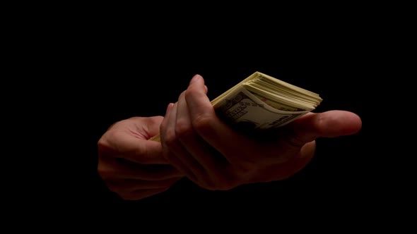 Male hands holding many banknotes isolated on black background