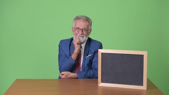 Handsome Senior Bearded Businessman Against Green Background