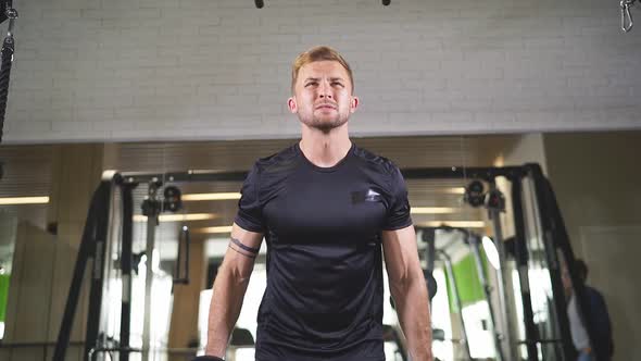 Young Man in Sportswear Lift Weights While Working Out in Gym