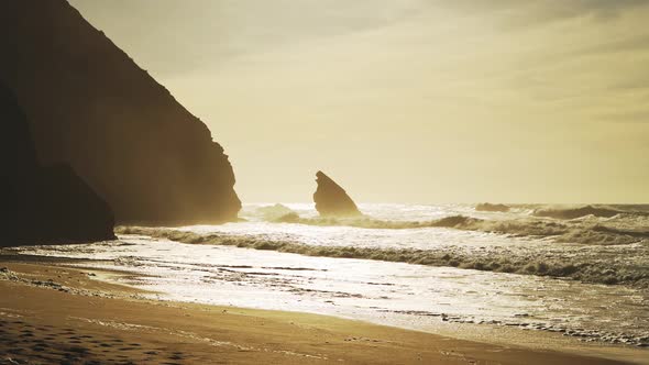 Praia Da Adraga Beach in Portugal, Lisbon (Lisboa) at Beautiful Orange Sunrise, With Waves Breaking