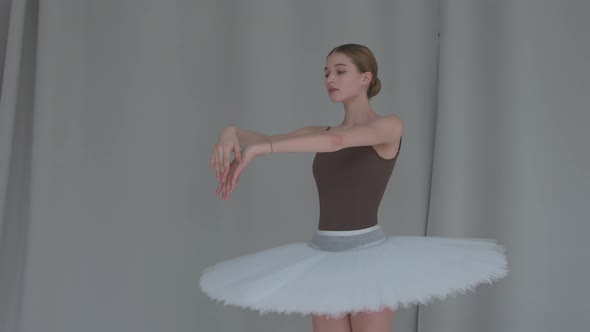 Ballerina on a Light Coloured Background Performs Smooth Movements with Her Hands, Graceful