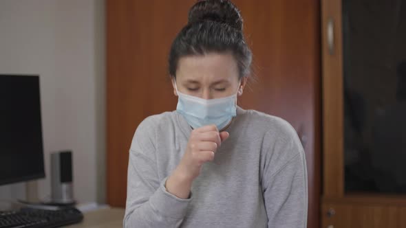 Ill Caucasian Woman in Coronavirus Face Mask Coughing Looking at Camera with Sad Facial Expression