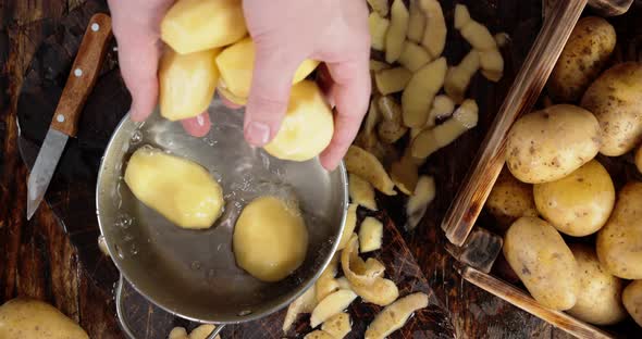 Hand Men Put Peeled Potatoes in a Pot with Water. 