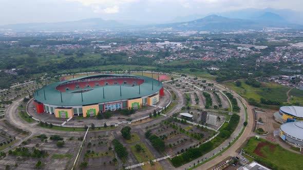 Aerial view of The largest stadium of Pakansari Stadium from drone. Indonesia. With noise cloud
