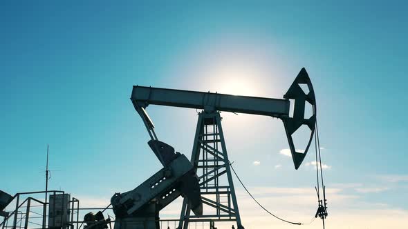 Working Oil Pump in an Oil Field in Sunlight