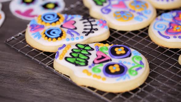 Step by step. Decorating sugar skull cookies with different color royal icing.