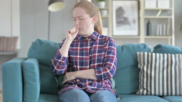 Young Woman Sitting on Couch And Coughing