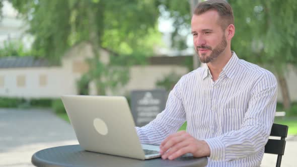 Outdoor Middle Aged Man Talking on Video Call on Laptop