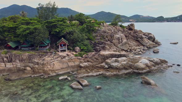 Aerial View of Island Beach with Bungalow and Rocky Coastline at Haad Khom Beach