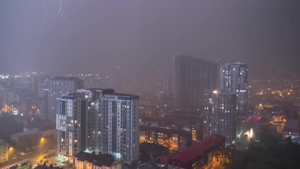 Night City with Skyscrapers and Luminous Windows at Thunderstorm and Lightning Flashes. Timelapse